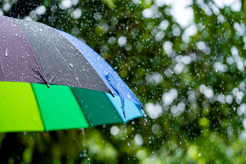 Wet colourful umbrella in rain with water drops. Rainy day - Rainy weather