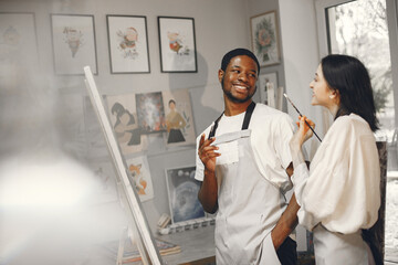 Obraz premium Mixed couple painting picture in workshop