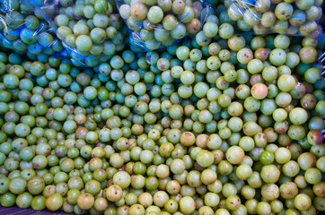 Fresh green Amla (Indian gooseberry) fruit from the local market. Daily necessary vegetables or fruit sold on the street. Dhaka, Bangladesh. November 2019