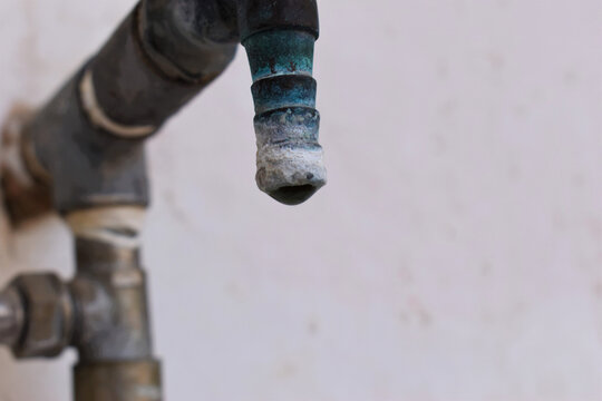 A faucet with a water drop closeup , Water consumption concept