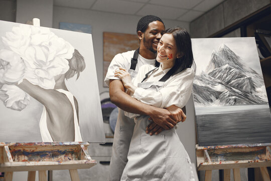 Mixed couple painting picture in workshop