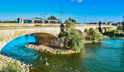 Tranvía cruzando el puente de Jorge V sobre el río Loira en la ciudad de Orleans, Francia