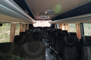 Fototapeta premium Comfortable bus with overhead compartments under cloth seats and curtains on windows