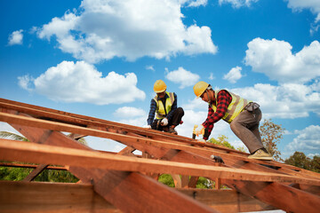 Builders in work clothes install new roofing tools, roofing tools, electric drill and use them on...