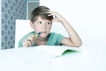 Naklejka premium boy with book does school homework. Back to school. Unhappy schoolboy with textbooks. Distance learning
