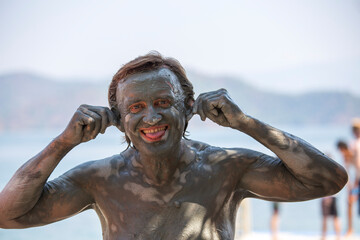 Fototapeta na wymiar Portrait happy man who takes a mud bath. Dalyan, Turkey