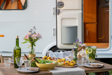 Variety of fresh vegetarian homemade food on served table against travel house