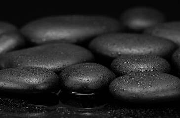 black stones with drops on black background black pebbles