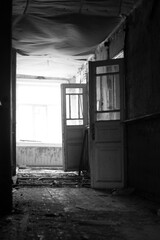 corridor of old abandoned wooden rural hospital in black and white