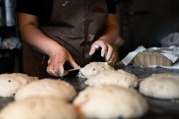 Girl baker forms bread on the table