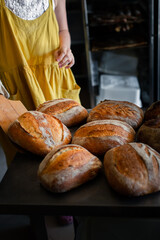 Girl baker takes bread out of the oven with a shovel