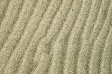 Fototapeta na wymiar Beautiful wavy beach sand close up