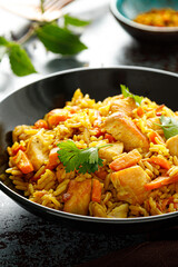 Pilaf or pilau with chicken, traditional uzbek hot dish of boiled rice, chicken meat, vegetables and spices on plate.