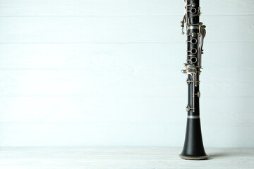 Clarinet on white wooden background, space for text