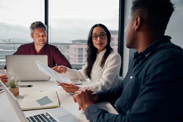 A group of multiethnic businesspeople talking at a table regarding the business growth