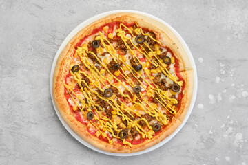 Top view of small size pizza with minced beef meat, sweet corn and mustard
