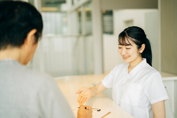 病院の受付にいる女性（患者）
