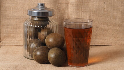 Monk fruit or Luo Han Guo. Dried fruits for healthy sweetener drink. Natural herbal remedy and glass bottle background. Monk fruit drink for who concern health and sugar substitute. 