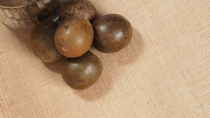 Monk fruit or Luo Han Guo. Dried fruits for healthy sweetener drink. Natural herbal remedy and glass bottle background. Monk fruit drink for who concern health and sugar substitute. 