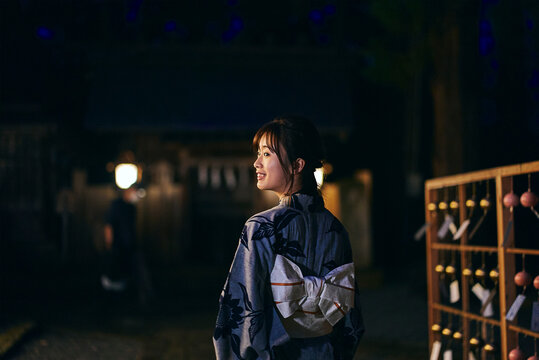 神社の参道を歩く浴衣を着た女性