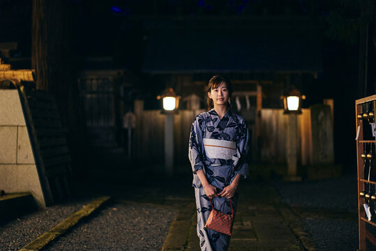 神社の参道を歩く浴衣を着た女性