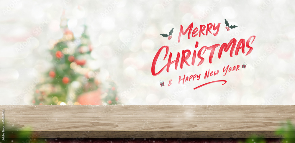 Aufkleber merry christmas and happy new year text over wood table top at blur bokeh xmas tree decor with strin