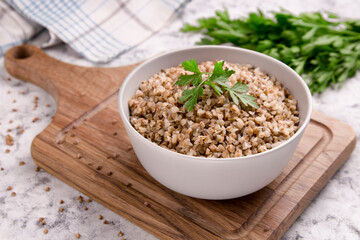 Freshly cooked buckwheat porridge in a plate on a gray background.