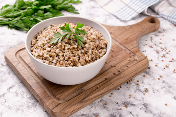 Freshly cooked buckwheat porridge in a plate on a gray background.