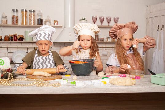 children sisters and brothers Americans prepare from dough for mom on mother's day children cooks for cook's day and Christmas