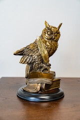 metal sculpture of an owl with books and a pen for writing.