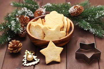 Homemade cookies on a wooden background with branches of a Christmas tree.  New year concept
