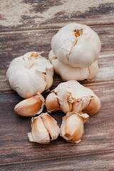 Garlic bulbs and cloves on rustic surface with copy space