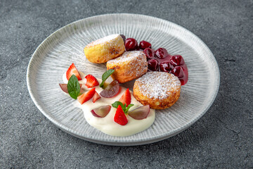 Sweet cottage cheese pancakes with jam and berries. Ready menu for the restaurant. Neutral gray blue textured background