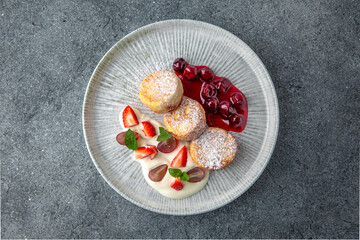 Sweet cottage cheese pancakes with jam and berries. Ready menu for the restaurant. Neutral gray blue textured background