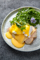 Sandwich with ham, cheese and herbs. Hearty, nutritious breakfast. Ready menu for the restaurant. Neutral gray blue textured background