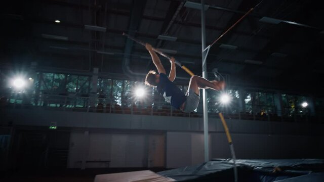 Pole Vault Jump: Professional Male Athlete Running with Pole Successfully Jumping over Bar. Determination, Motivation, Effort of Champion in Training. Cinematic Slow Motion Sport. Following Pan Shot