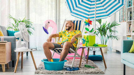 Man having a staycation and resting on a deckchair at home - obrazy, fototapety, plakaty