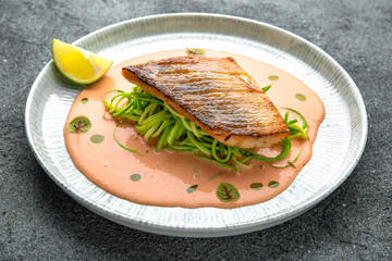 Fillet of sea bass or dorado with spinach paste. Ready menu for the restaurant. Neutral gray blue textured background