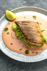 Fillet of sea bass or dorado with spinach paste. Ready menu for the restaurant. Neutral gray blue textured background