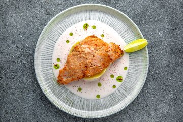 Chicken chop in batter with mashed potatoes and creamy sauce. Ready menu for the restaurant. Neutral gray blue textured background