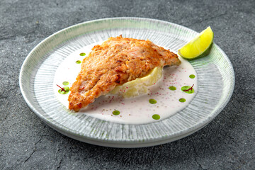 Chicken chop in batter with mashed potatoes and creamy sauce. Ready menu for the restaurant. Neutral gray blue textured background