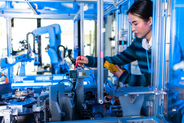 Asian female Engineers Maintenance Robot Arm at Lab. he are in a High Tech Research Laboratory with Modern Equipment. Technology and Innovation Concept..