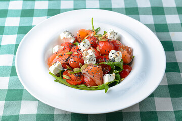 Tomato and salmon salad with cheese and spices. Traditional Italian cuisine, Italian concept.
