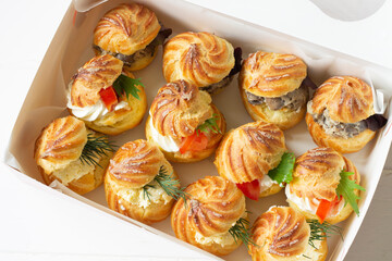 Profiterole staffed  with cream cheese mushrooms and  tomatoes. Food delivery, delivery box.Cheese profiteroles, profiterole buffet