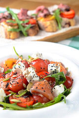 Tomato and salmon salad with cheese and spices. Traditional Italian cuisine, Italian concept.