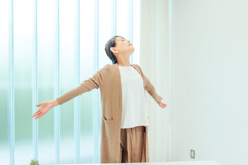 部屋でストレッチする中高年の女性
