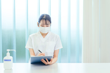 カウンセリングするマスクをする白衣姿の女性
