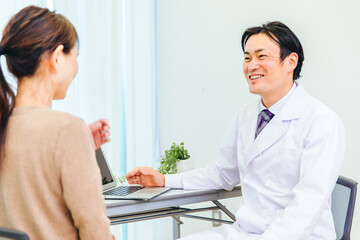 Fototapeta premium 診察する男性医師と女性患者（説明） 