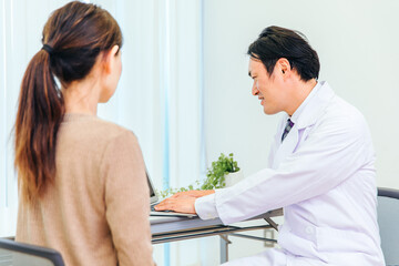 Fototapeta premium 診察する男性医師と女性患者（ノートパソコン） 