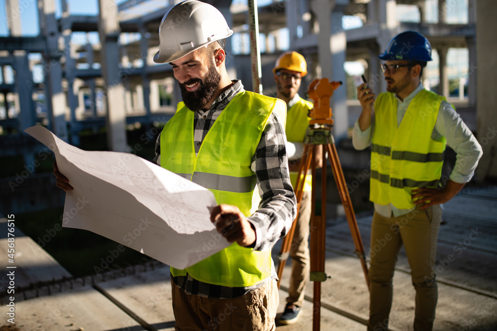 Wall mural Architect and engineer construction workers working at outdoors construction site